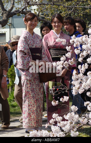 Due tradizionalmente condita le giovani donne alla ricerca di Cherry Blossoms sulla via dei Filosofi si trova a Kyoto, Giappone Foto Stock