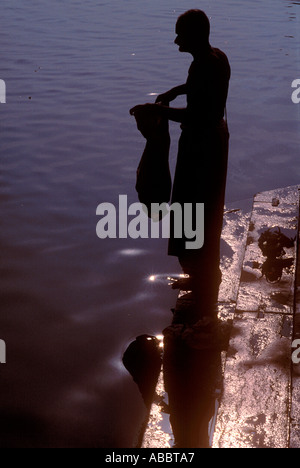 Uomo indiano il lavaggio della biancheria a rive del fiume sacro Gange in Banaras varanasi fino in India Foto Stock