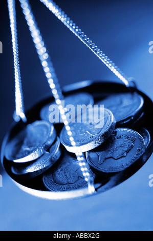 Pound monete in pan di bilance Foto Stock