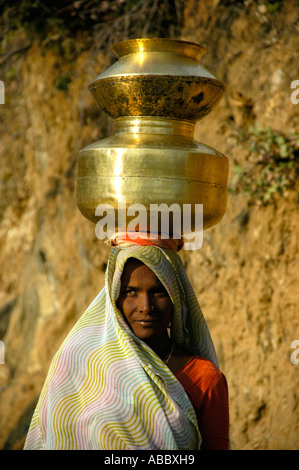 Indian donna vestita di sari colorati sta portando vasi d'acqua sul suo capo il Rajasthan in India Foto Stock