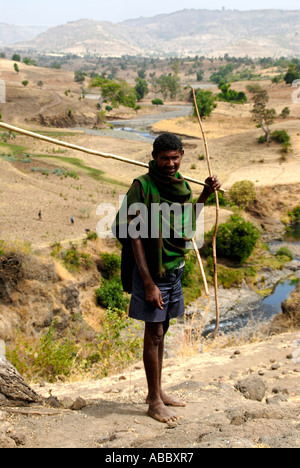 Pastore si erge a piedi nudi in arido paesaggio vicino Bahir Dar Etiopia Foto Stock