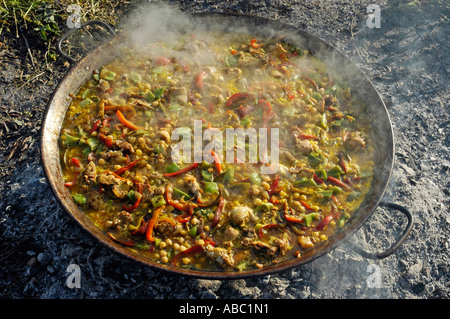 La cottura della specialità spagnola di paelle in una padella su un fuoco aperto, Spagna Foto Stock