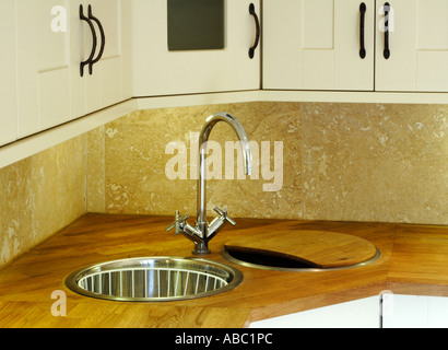 Vista ravvicinata del rubinetto miscelatore da cucina in acciaio inossidabile con lavandino in legno e superficie di lavoro Foto Stock