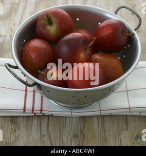 Le mele rosse in scolapasta Foto Stock