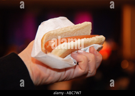 Mano che tiene un hot dog Foto Stock