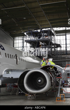 Aereo di linea tecnici della manutenzione di lavorare su un Boeing 737 CFM-56 motore jet in aeroporto appendiabiti Foto Stock