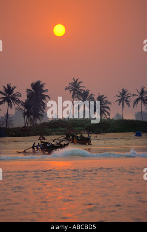 I pescatori tornano da una battuta di pesca all'alba in una mattinata nebbiosa. Spiaggia di Benaulim Salcete Goa India Foto Stock