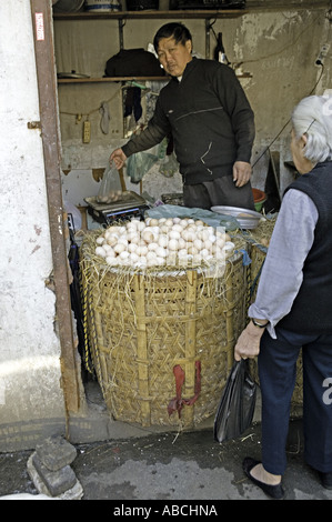 Cina Shanghai venditore di pesatura e la vendita di uova fresche dal piccolo negozio vetrine su una strada trafficata in Shanghai Foto Stock