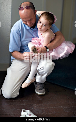 CAROLINA DEL SUD COLUMBIA moderno giovane padre aiuta la sua bellissima figlia di cinque anni ha messo in scarpe da ballo per il suo recital Foto Stock