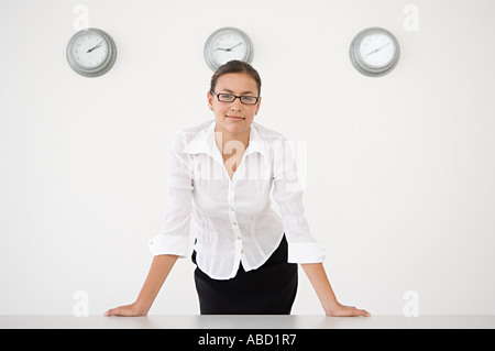 Imprenditrice si fermò di fronte a tre orologi da parete Foto Stock