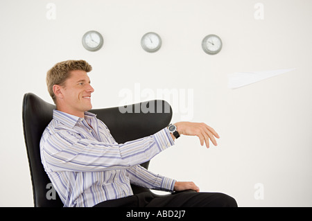 Imprenditore gettando un aeroplano di carta Foto Stock