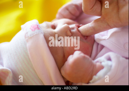 Nuovo nato ragazza succhiare il dito Foto Stock