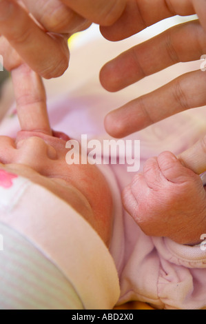 Nuovo nato ragazza succhiare il dito Foto Stock