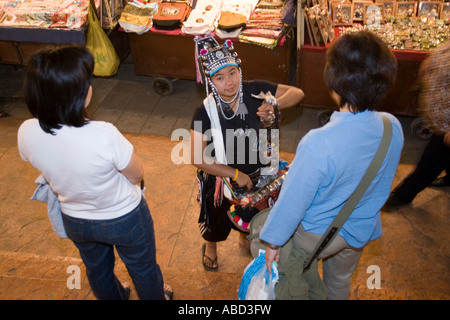 Akha hill tribe donna vende artigianato ninnoli dal vassoio Chiang Mai Night Market a nord della Thailandia Foto Stock