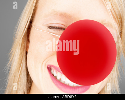 Donna che indossa un clown naso Foto Stock