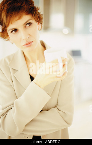 Una premurosa donna avente una tazza di tè Foto Stock