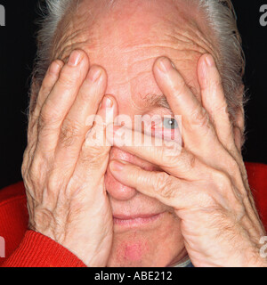 Senior uomo che copre il suo occhio destro con la mano Foto Stock