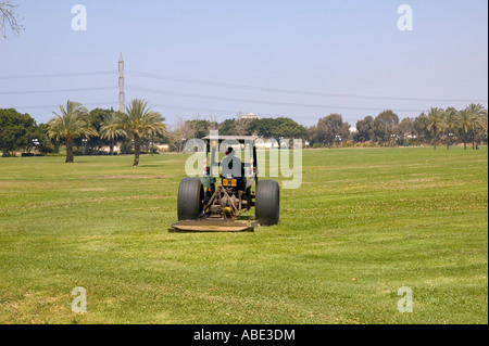 Il trattore Falciare il prato in un parco Foto Stock