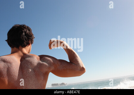 L'uomo flettendo i suoi muscoli Foto Stock