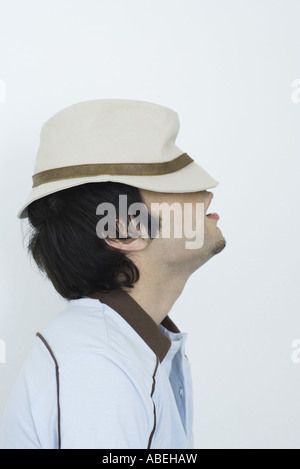 Giovane uomo che indossa hat tirato giù sopra gli occhi, vista laterale Foto Stock