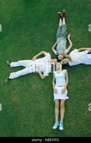 Un gruppo di giovani amici sdraiati sull'erba con teste insieme Foto Stock