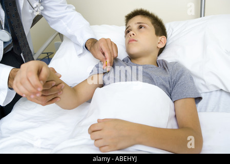 Medico tenendo bambino della temperatura Foto Stock