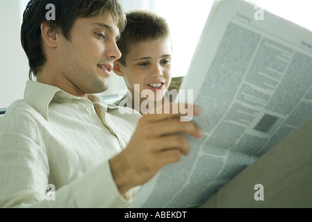 Padre e figlio leggendo il giornale insieme Foto Stock