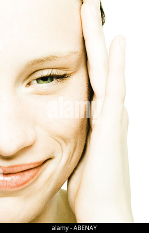 Ragazza adolescente il viso, le mani sul tempio, extreme close-up Foto Stock