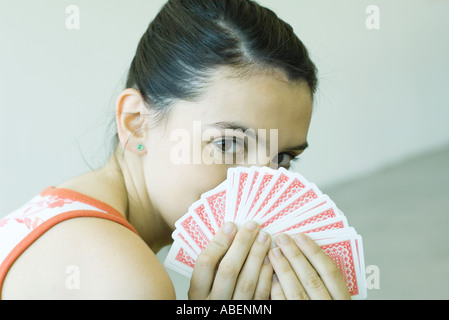 Teen girl cerca su mano di carte Foto Stock