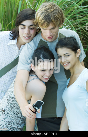 Giovani amici prendendo foto di gruppo con un telefono cellulare Foto Stock