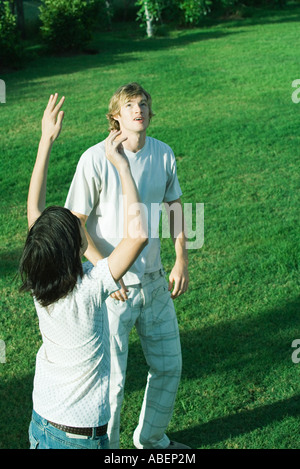 Giovane maschio amici giocando con il pallone da calcio sul prato Foto Stock