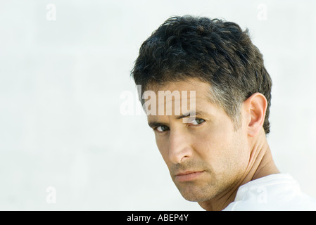 L'uomo, guardando sopra la spalla in telecamera, ritratto Foto Stock