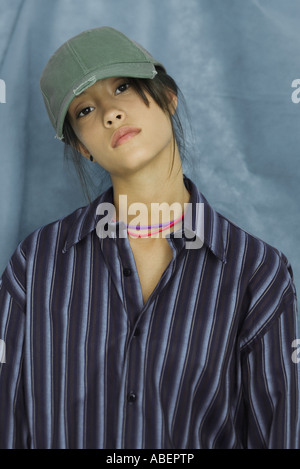 Ragazza adolescente indossando grande button down shirt e cappello da baseball, ritratto Foto Stock