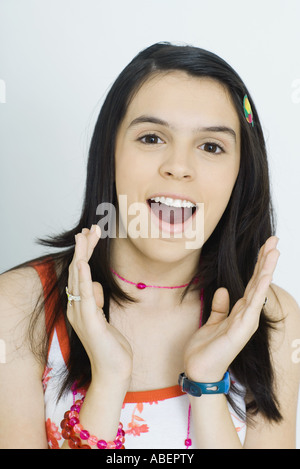 Teen girl cerca sorpreso, tenendo in alto le mani Foto Stock