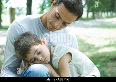 Ragazzo e padre, il bambino addormentato in uomo di giro Foto Stock