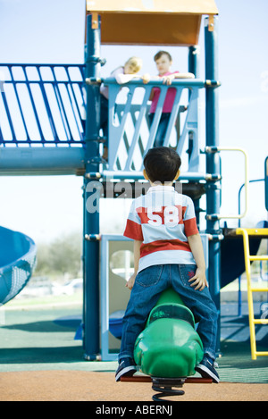 I bambini sulle attrezzature per parchi gioco Foto Stock