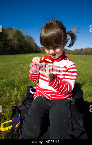 Una ragazza giovane età 4 studi un bruco sul pascolo comune a Newburyport MA Foto Stock