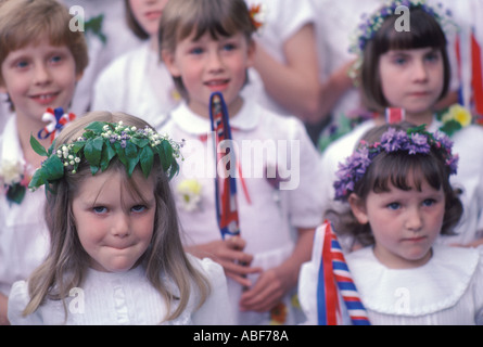 Maggio fiori copricapo ragazze scolastiche che seguono il Re e la Regina attraverso il villaggio Castleton Garland Day 29 maggio 1980s Derbyshire Regno Unito Foto Stock