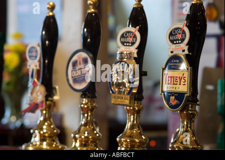 Tirare la birra in un pub tradizionale nel Regno Unito con marche di birra sulla parte anteriore Foto Stock