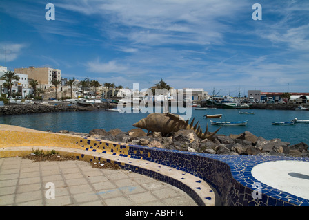 Dh Puerto del Rosario Fuerteventura Scuptures artistico banco del sedile sul lungomare e le barche nel porto Foto Stock