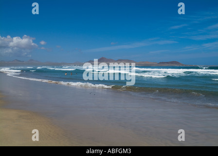 Dh Playa de Famara Lanzarote Lanzarote spiaggia sabbiosa wave surf la rottura a terra Playa Famara bay Foto Stock