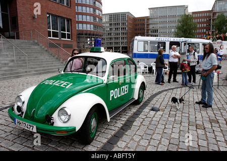 La gente guarda un Volswagen Beetle auto della polizia di Amburgo, Germania Foto Stock