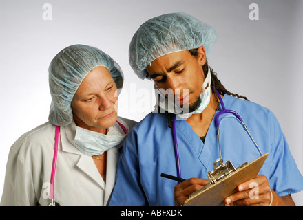 Giovane medico nero con clip board consulting senior medico donna nella retina per capelli con maschera rimossa Foto Stock