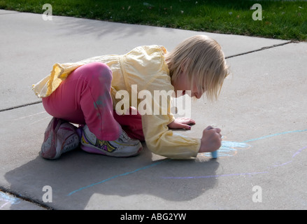 Il mio bambino di 6 anni nipote occupato con la sua arte gesso nel nostro passo carraio. Foto Stock