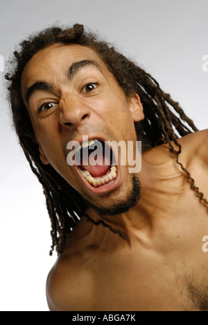 Uomo nero con dreadlocks urla e urlando Foto Stock