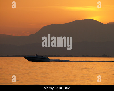 Powerboat velocizzando la crociera sul Lago di Garda vicino a Peschiera del Garda al tramonto Italia Foto Stock