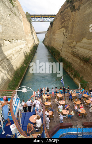 Stretta pressione per la nave da crociera che passa attraverso lo storico canale di Corinto passeggeri a tavoli e sedie sul ponte di poppa Peloponneso Grecia Europa Foto Stock