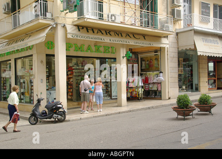 Scena di strada nella città di Corfù sull'isola greca di Corfù farmacia shop & shoppers nel traffico principalmente free & pedestrianise parte della città vecchia in Grecia Foto Stock