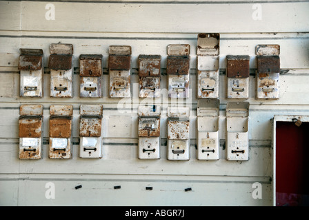 Il vecchio metallo arrugginito cassette postali inchiodati ad un appartamento sit parete vuota. Foto Stock
