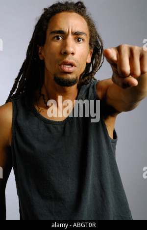 Scioccato arrabbiato giovane uomo nero con dreadlocks puntare il dito Foto Stock